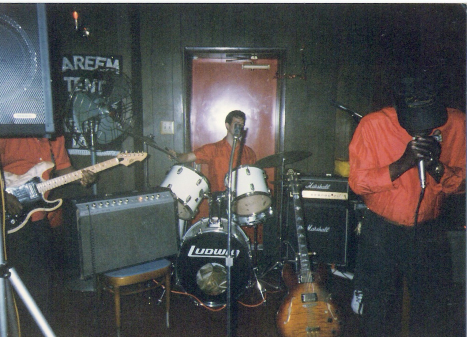 Photo of Eric Hepperle playing drums in Robert Johnson's Blues Band at one of our gigs in Waterloo, IA (1997?) (l-r: Eddie Culpepper (lead guitar), Eric, Robert Johnson (harmonica and vocals). Not pictured: Kenneth "Joe" Hepperle (bass), Frank (rhythm guitar)